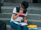 Status studenta - student siedzący na schodach
