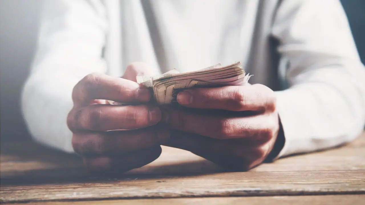 Koniec świadczenia rehabilitacyjnego - co dalej - zbliżenie na pieniądze w dłoniach