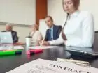 Kontrakt na stole, z tylu ludzie