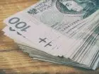 Zasiłek przedemerytalny - banknoty 100 zł na desce