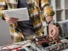 Elektronik podczas pracy z urządzeniem, czyta dokumentację