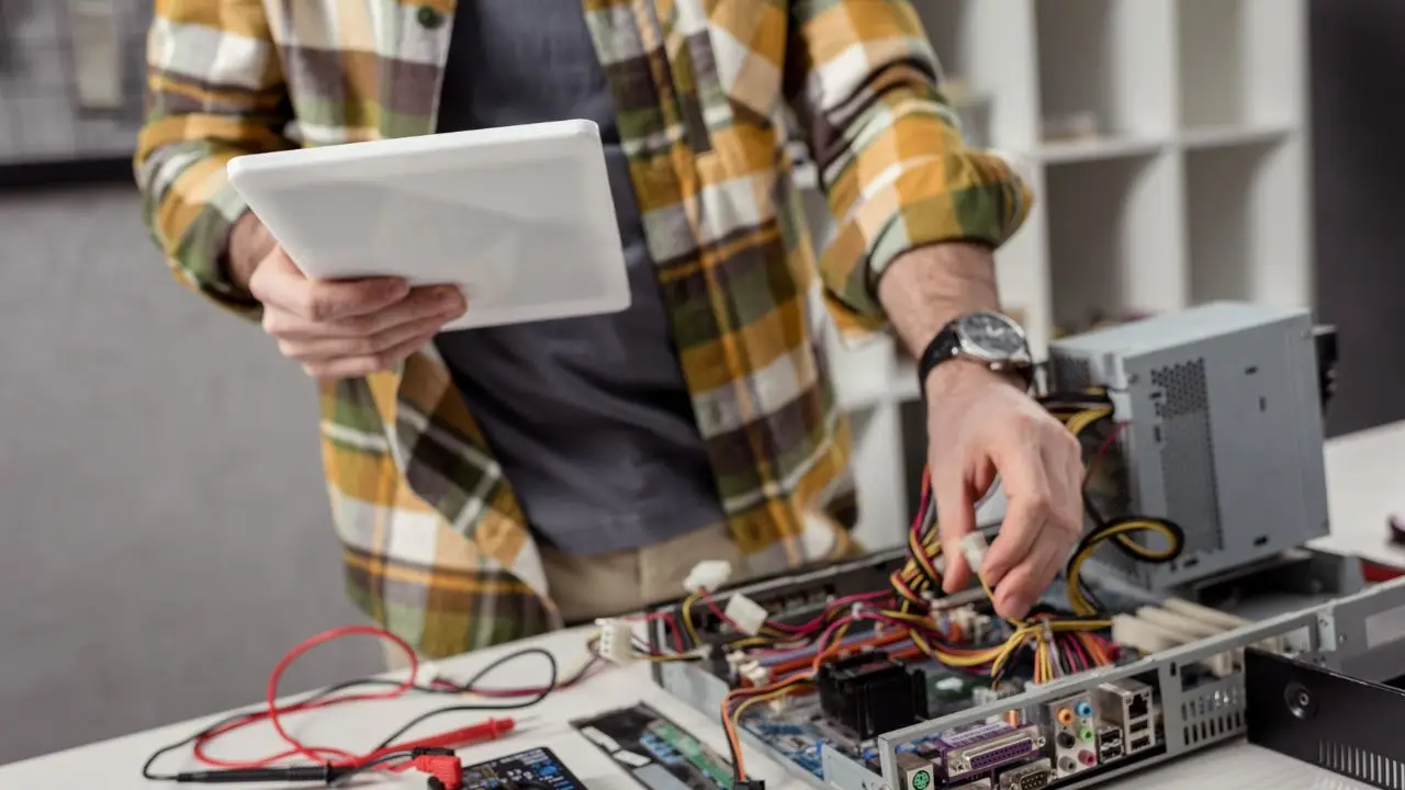 Elektronik podczas pracy z urządzeniem, czyta dokumentację