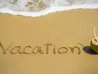 Podanie o urlop - napis vacation na pisaku na plaży