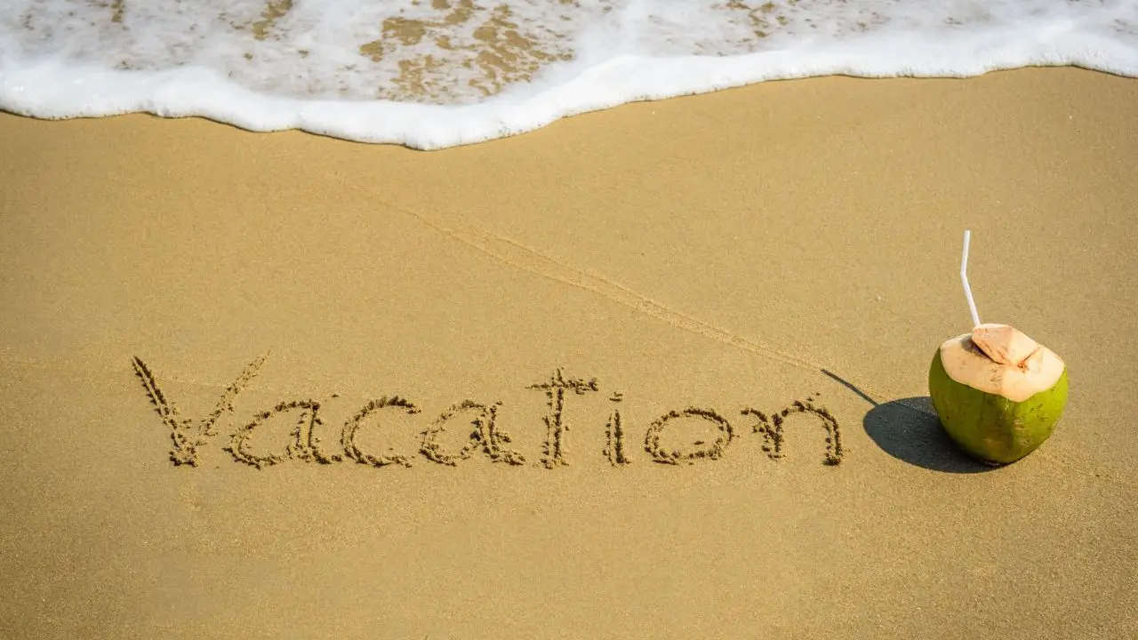 Podanie o urlop - napis vacation na pisaku na plaży