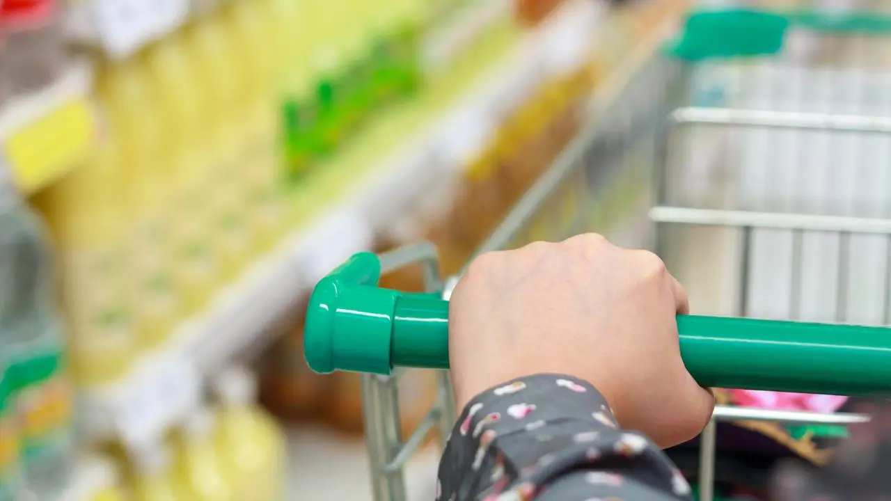 Ograniczenie handlu w sobotę - zblizenie na dloń osoby pchającej wózek sklepowy