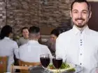 Ile zarabia kelner - kelner trzymający tacę w restauracji