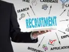 Metody selekcji pracowników - mężczyzna unoszacy dłoń pod napisem recruitment - wokół ikony i napisy