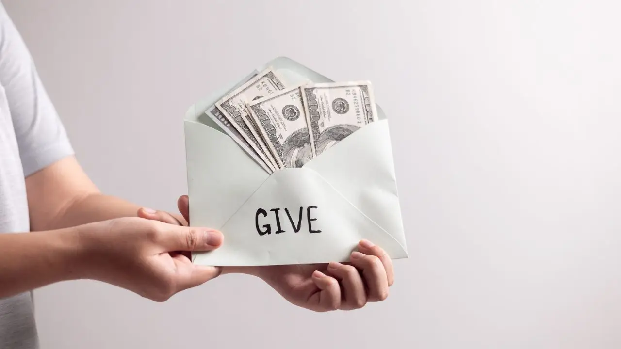 Darowizna - koperta z dolarami podpisana "give"