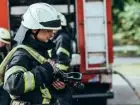 Dodatek dla strażaków OSP - strażak przy wozie strażackim