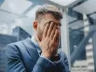Frustracja - mężczyzna trzymający się za twarz, wyrażający uczucie frustracji