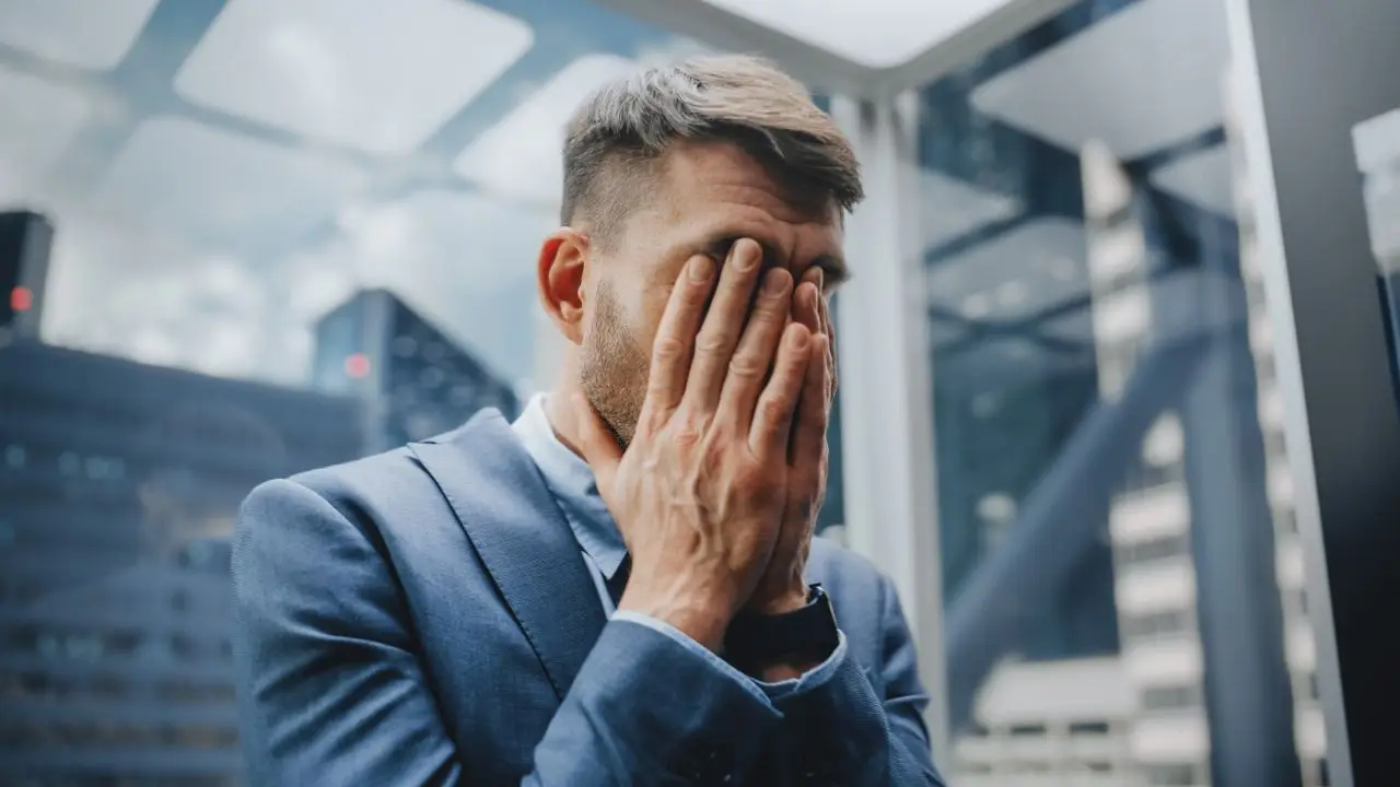 Frustracja - mężczyzna trzymający się za twarz, wyrażający uczucie frustracji