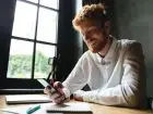 Mały ZUS plus - przedsiębiorca uśmiechający się do smartfona