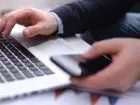 Nierejestrowana działalność gospodarcza - mężczyzna pracujący przy laptopie z telefonem w dłoni
