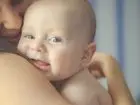 Nowy urlop dla mam i ojców - mama przytula noworodka i uśmiecha się