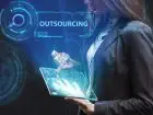Outsourcing - kobieta z tabletem w dłoni, w tle napis outsourcing