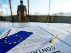 VIES - mężczyzna w tle dokumentu umowy i flagi UE