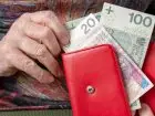 Wdowia emerytura - zbliżenie na dłonie kobiety wyciągającej banknoty z portfela