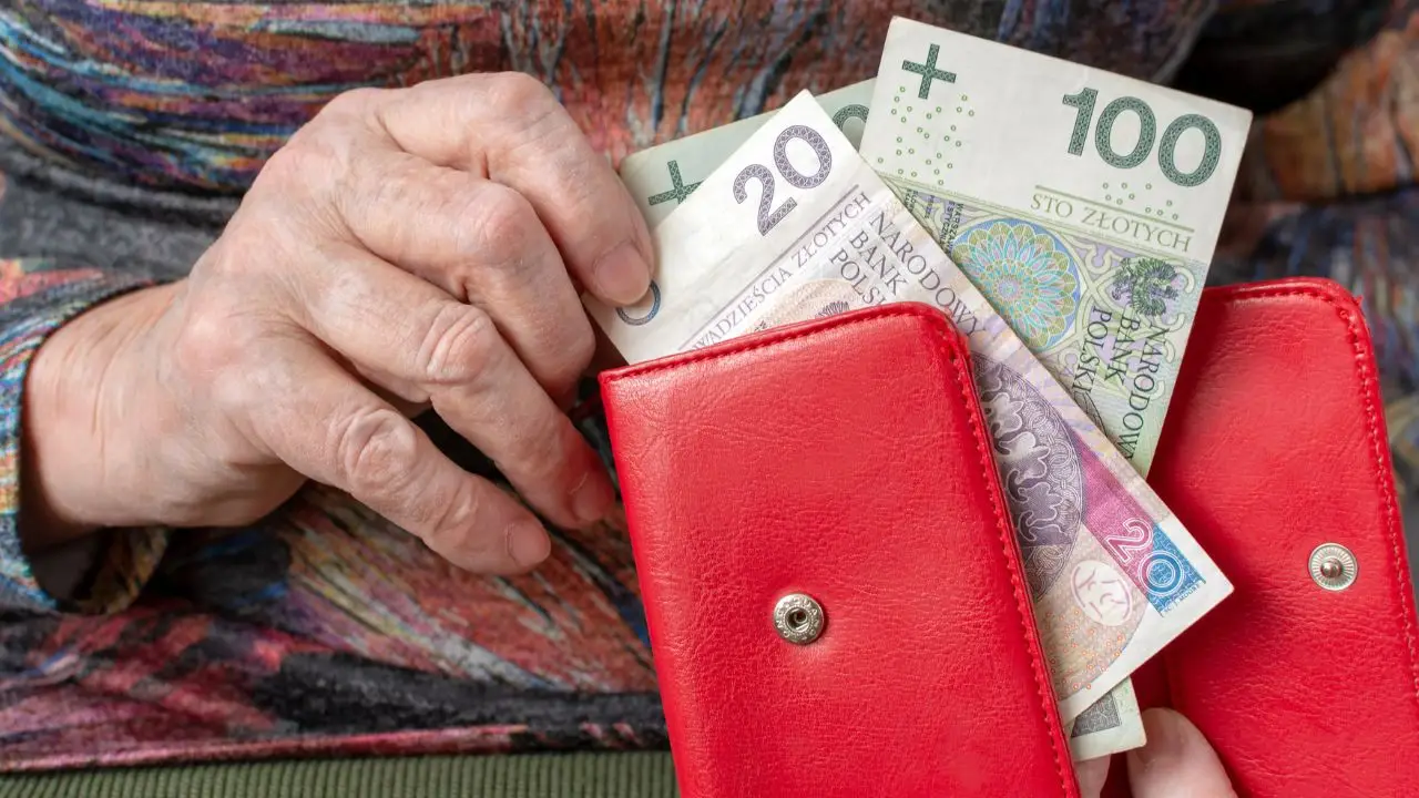 Wdowia emerytura - zbliżenie na dłonie kobiety wyciągającej banknoty z portfela
