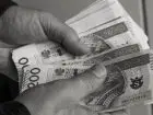 Za późno złożony wniosek o świadczenie rehabilitacyjne - banknoty 200 zł w dłoniach