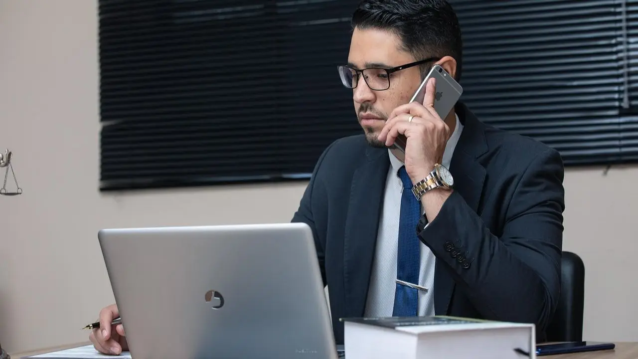 KRK online - mężczyzna rozmawiający przez telefon, korzystający z laptopa