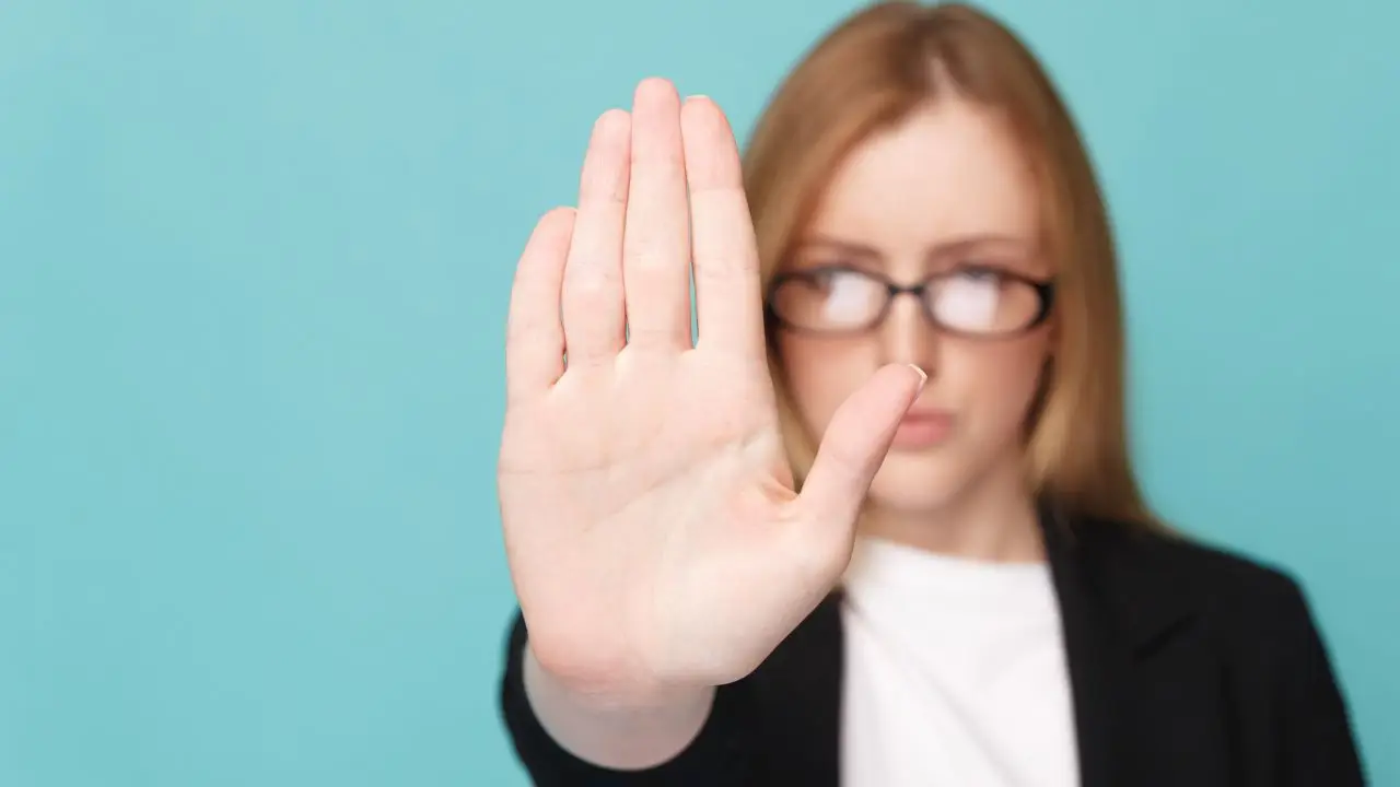 Odmowa urlopu na żądanie - kobieta z uniesioną dłonią w akcie sprzeciwu