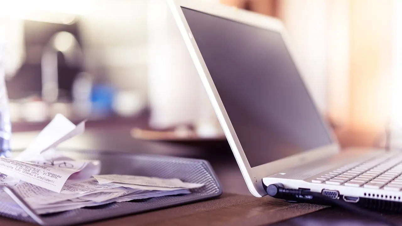 Zwolnienia grupowe - laptop na biurku i dokumenty