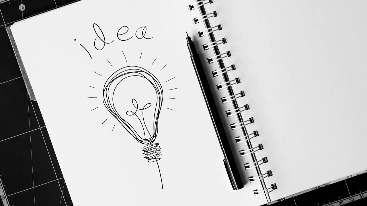 Burza mózgów - żarówka z napisem idea w notatniku