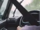 Dopłata do prawa jazdy - zbliżenie na kierownicę, za którą siedzi kierowca