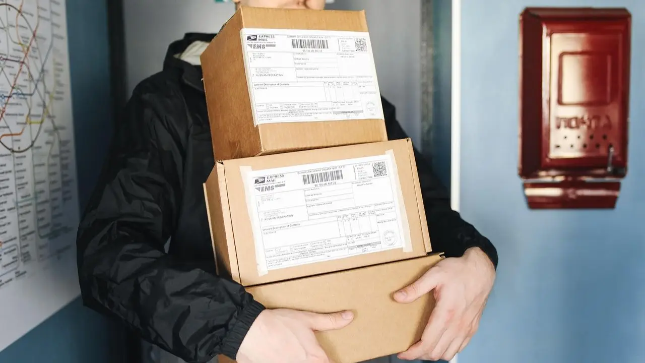 Ile zarabia kurier inpost - symboliczne zdjęcie przykładowego kuriera trzymającego paczki