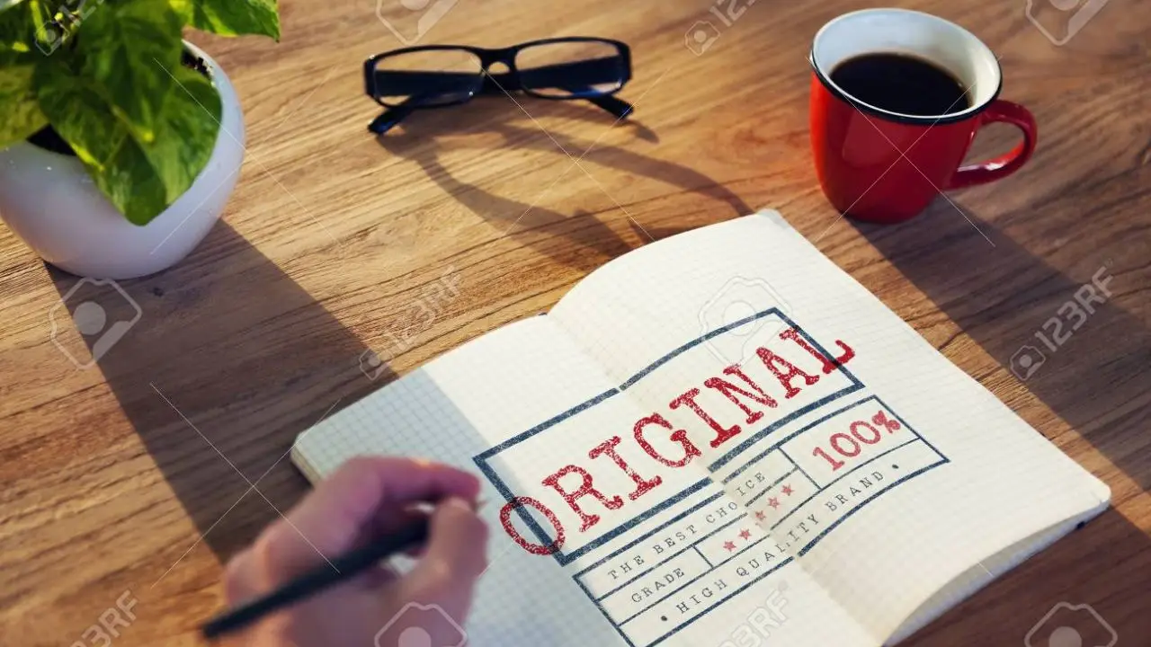 Plagiat - napis original w zeszycie, obok kawa, okulary i roślina
