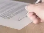 Umowa kupna sprzedaży - dłoń osoby podpisującej umowę