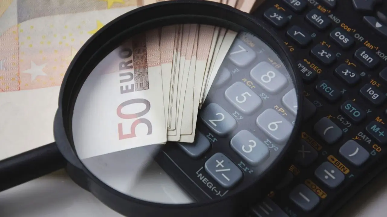 Wadium - lupa i banknoty na kalkulatorze