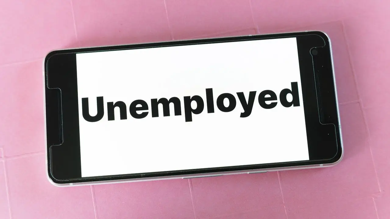 Bezrobocie cykliczne - napis unemployed na telefonie