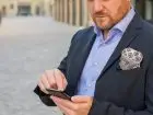 Prokurent - elegancko ubrany mężczyzna z telefonem w dłoni