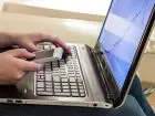 Telepraca - osoba pracują przy laptopie z telefonem w dłoni
