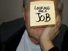 Mężcyzzna z kartą z napisem looking for a job na twarzy