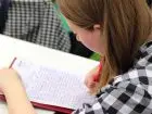 Praca dla studenta - kobieta notująca w zeszycie