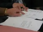 Przedłużenie umowy o pracę - zbliżenie na dłonie dwóch osób omawiających dokumenty