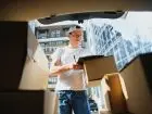 Young,Male,Courier,With,Parcels,Near,Delivery,Service,Car