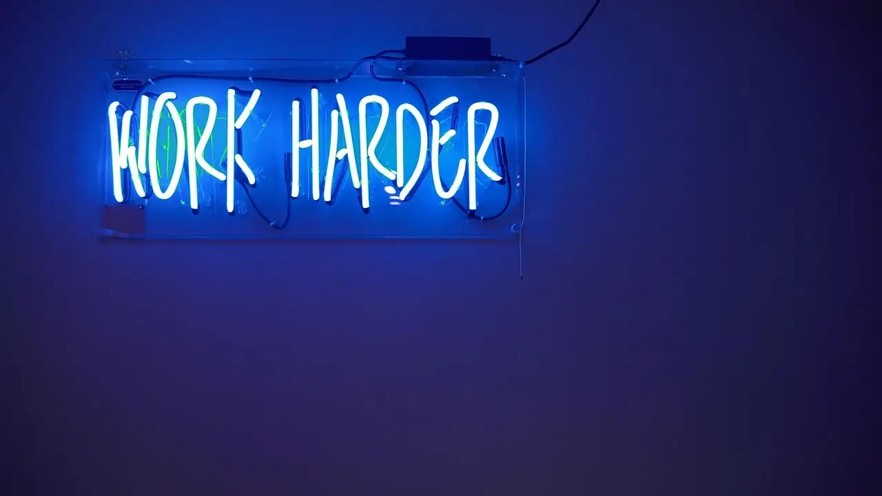 Motywacja do pracy - napis work harder na ciemnoniebieskim tle