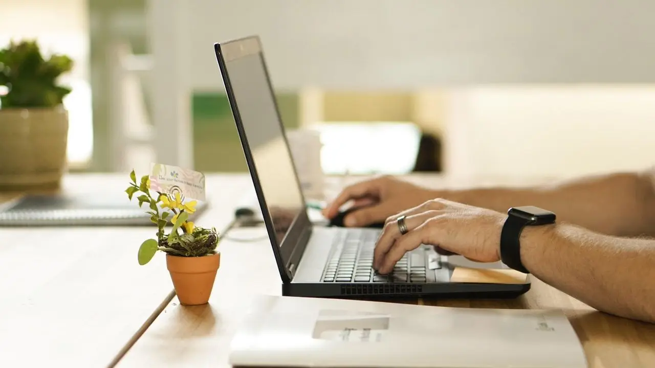 Zawód - dłonie osoby pracującej przy laptopie