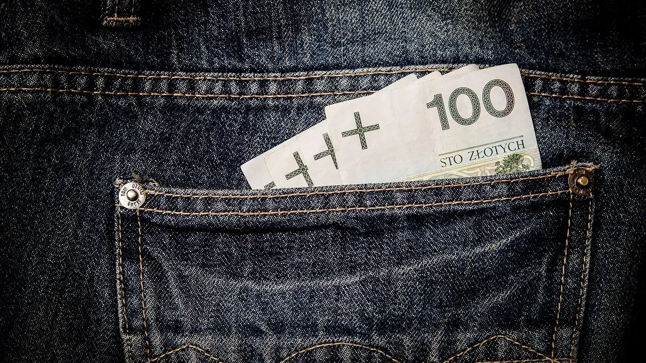 Jakie wynagrodzenie - banknoty 100 zł wystające z tylnej kieszeni spodni