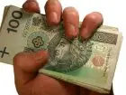 Umowa o pracę - stawka - banknoty 100 zł w dłoni