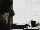 Freelancer - praca w domu - kobieta przy komputerze z kubkiem w dłoniach