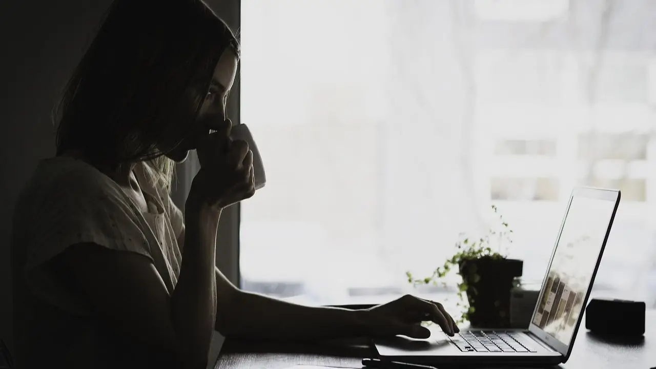 Freelancer - praca w domu - kobieta przy komputerze z kubkiem w dłoniach
