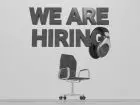 Portale z pracą - napis we are hiring nad krzesłem biurowym