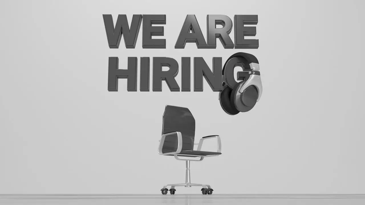 Portale z pracą - napis we are hiring nad krzesłem biurowym