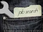 Portale z ogłoszeniami o pracę - napis na kartce "job search" w kieszeni spodni obok klucza