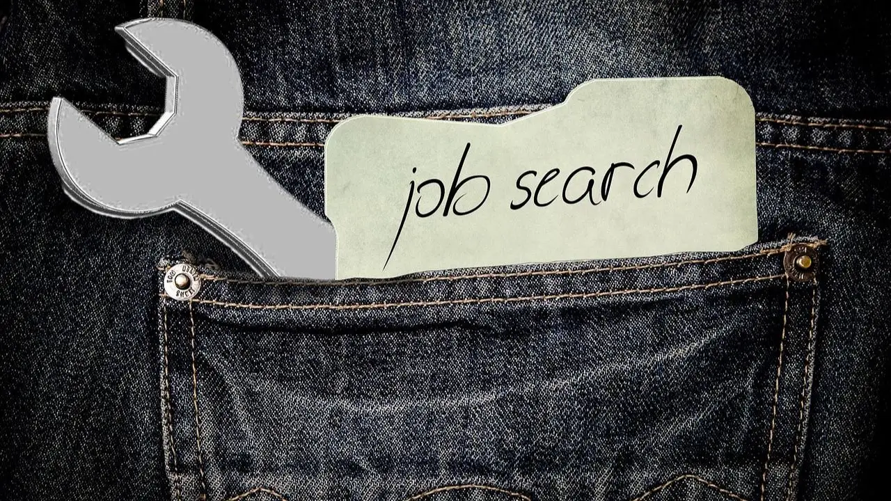 Portale z ogłoszeniami o pracę - napis na kartce "job search" w kieszeni spodni obok klucza