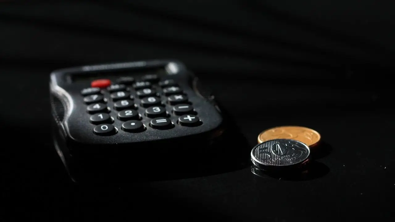 Najniższa krajowa 2026 netto do 26 roku życia - kalkulator i monety na czarnym tle